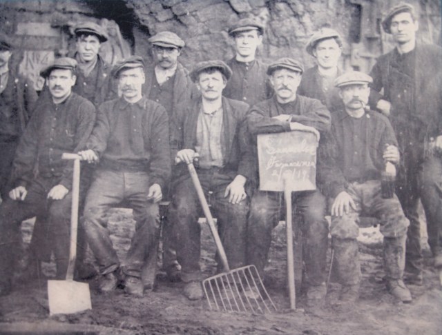 Eleven men outside a furnace at Summerlee Ironworks in 1919